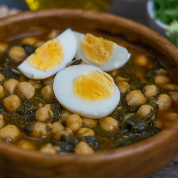 Espinacas con garbanzos y huevo duro en cazuela de barro - plato casero mediterráneo
