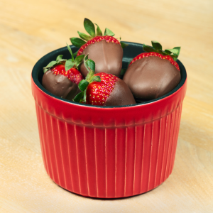 Fresones con cobertura de chocolate en bol rojo