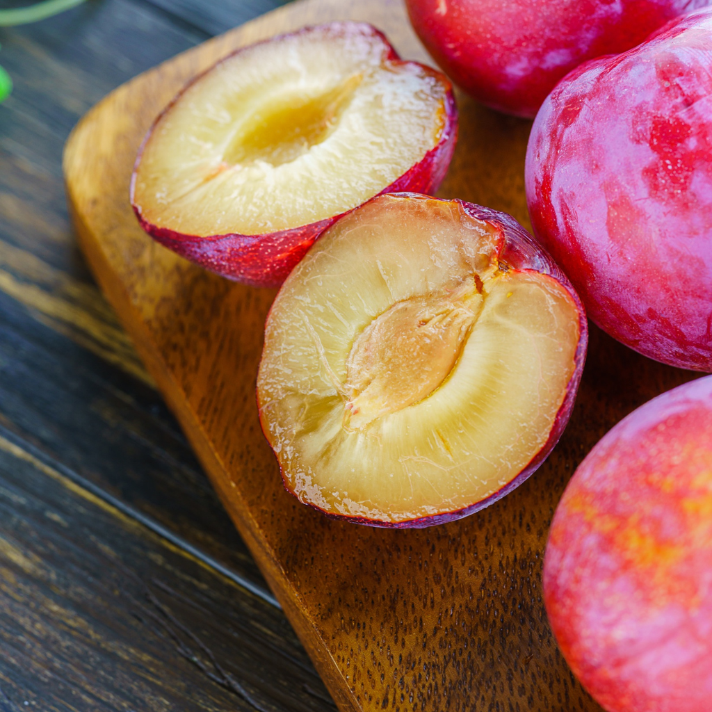 Ciruela roja abierta mostrando su pulpa