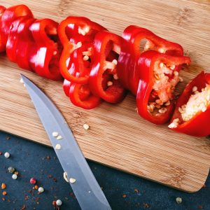 Rodajas de pimiento californio rojo fresco sobre tabla de madera