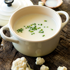 Crema de coliflor casera servida en cuenco con cebollino.