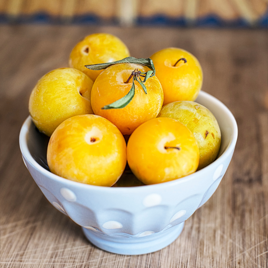 Bol con ciruelas amarillas frescas y jugosas