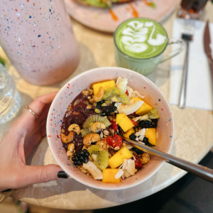 Bol saludable con kiwi verde,, mango y frutos secos