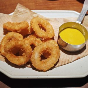 Aritos de cebolla fresca crujientes caseros recién fritos con salsa