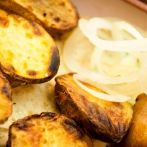 Patatas al horno con cebolla dulce fresca en receta casera