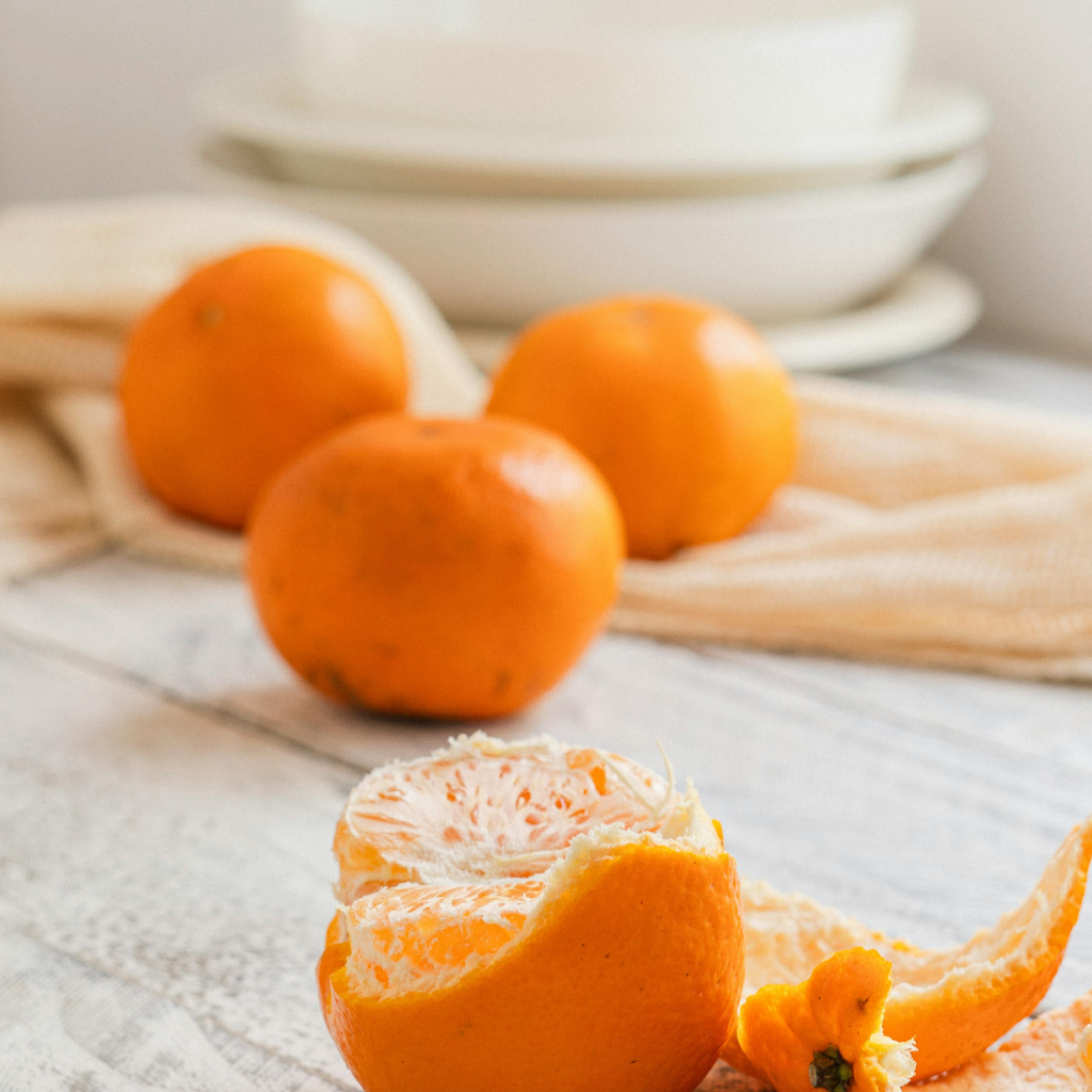 Mandarinas frescas peladas y enteras sobre fondo blanco
