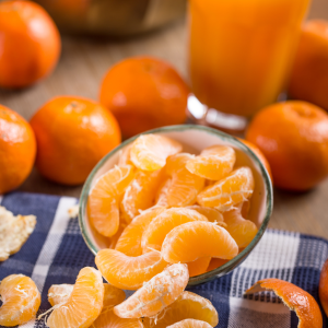 Gajos de mandarina fresca en cuenco con zumo natural