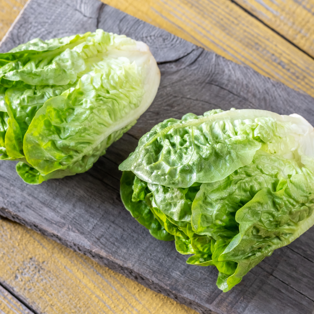 Corazones de lechuga baby frescos sobre mesa de madera de cocina