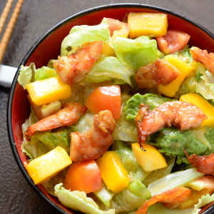 Ensalada fresca con dados de mango, lechuga y gambas salteadas