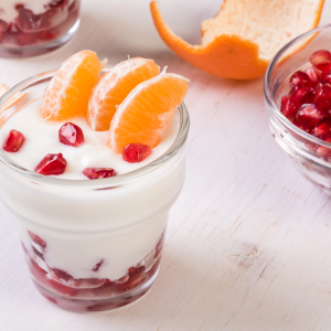 Yogur cremoso con gajos de mandarina hoja y granada