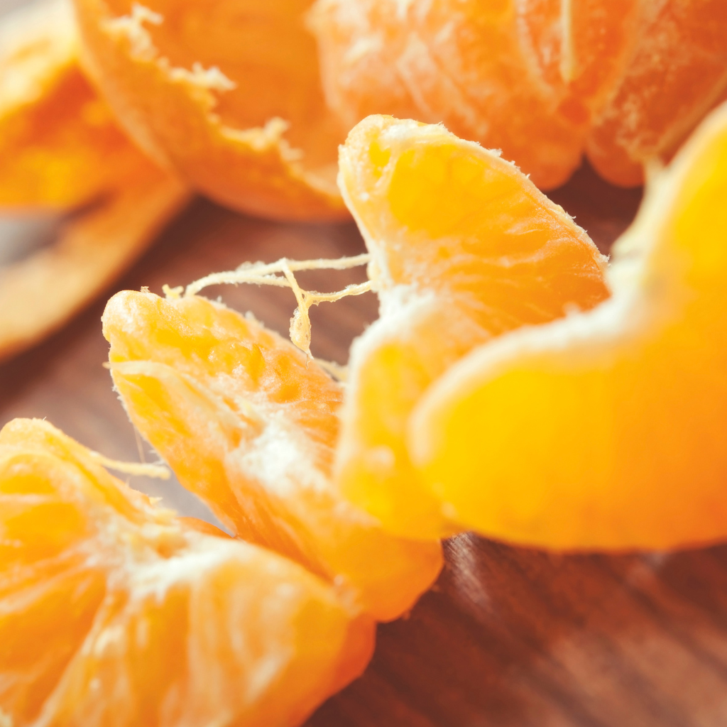 Gajos de mandarina fresca sobre mesa de madera