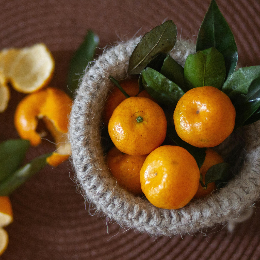 Mandarinas hoja en cesta artesanal con fondo rústico