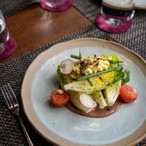 Ensalada de lechuga iceberg con huevo rallado, rabanitas y tomate