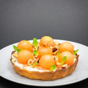 Tartaleta de nísperos con crema y frutos secos en presentación de postre
