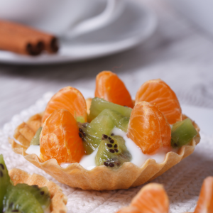 Tartaleta de fruta con gajos de mandarina y trozos de kiwi