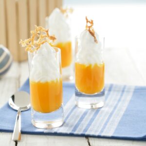Vasitos de crema de nísperos con nata montada y presentación elegante