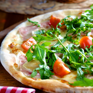 Pizza casera con rúcula y tomate cherry pera fresco