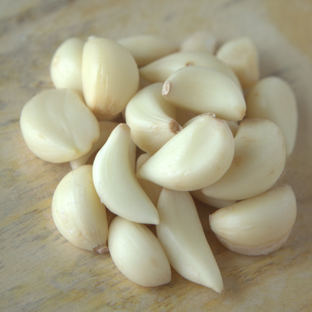 Dientes de ajo pelado fresco natural en tabla de madera