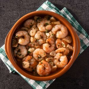 Gambas al ajillo tradicionales con ajo pelado fresco