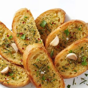 Tostadas de pan con ajo pelado fresco y hierbas aromáticas