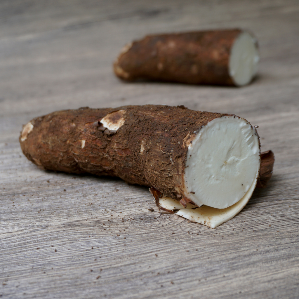 Yuca fresca partida sobre mesa de madera