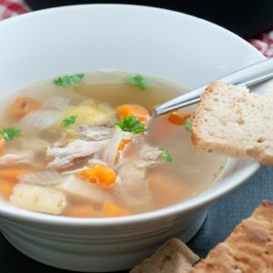 Sopa casera con yuca y verduras servida en cuenco blanco