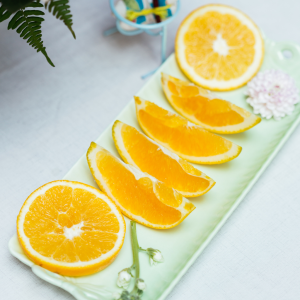 Naranja navel campo cortada en gajos frescos y jugosos en plato verde