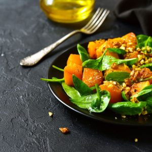 Ensalada templada de hoja de espinaca fresca con calabaza y nueces