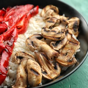 Arroz blanco con pimientos asados enteros y champiñones salteados