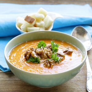 Crema de calabaza con nueces peladas y perejil en bol