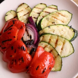 Pimientos asados enteros con calabacín a la plancha y cebolla morada